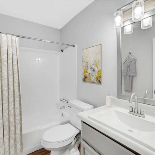 A white toilet sits next to a white sink in a bathroom.