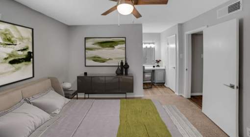 A bedroom with a bed, a nightstand, and a painting on the wall.