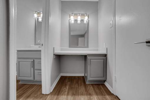 A white bathroom with a vanity and a mirror.