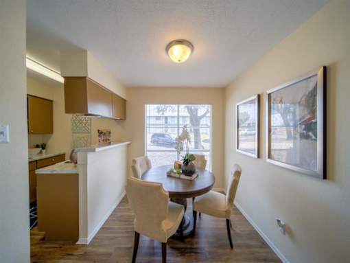 a kitchen and dining room with a table and chairs at Villas del Tesoro Apartments, Dallas, TX