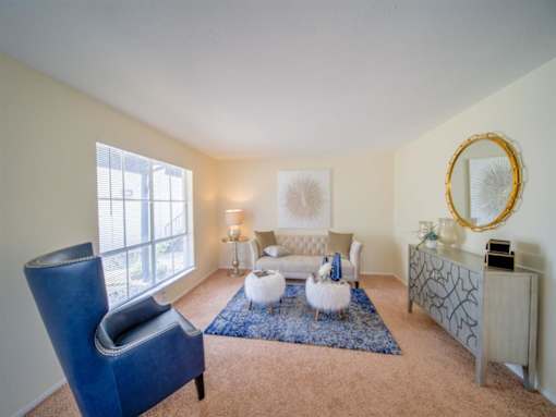 a living room with a couch and a chair and a table at Villas del Tesoro Apartments, Texas