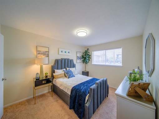 a bedroom with a bed and a window at Villas del Tesoro Apartments, Dallas