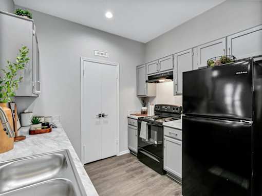 a kitchen with black appliances and white cabinets