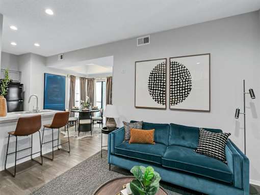 a living room with a blue couch and a dining room