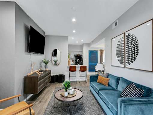 a living room with a blue couch and a tv