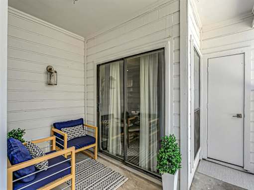 a patio with two chairs and a sliding glass door