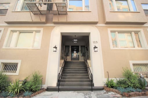 the front of a building with stairs and a door