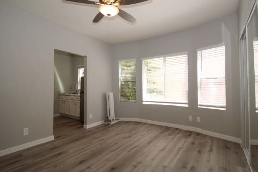 a living room with wood floors and a ceiling fan