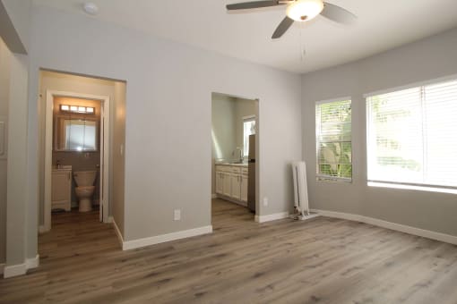 a living room with a wooden floor and a ceiling fan