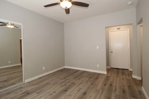 a empty room with wood floors and a ceiling fan