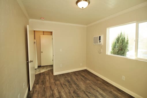 an empty room with a window and a door