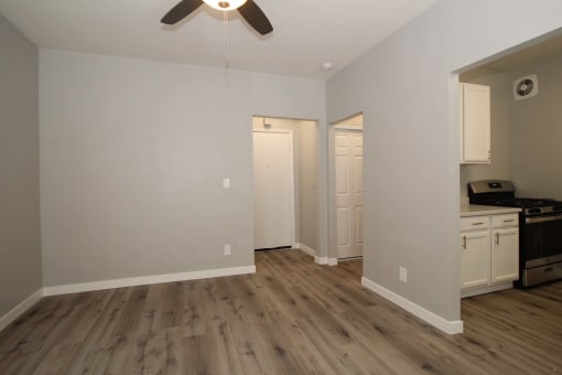 a living room with white walls and a ceiling fan