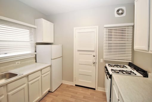 a kitchen with white cabinets and a stove and a refrigerator