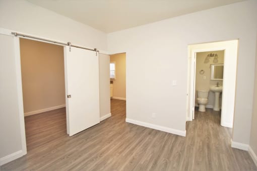 a bedroom with a door to a bathroom and a toilet