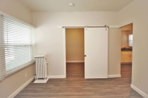 an empty living room with a window and a white sliding door