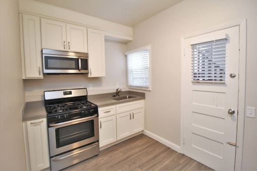 a kitchen with stainless steel appliances and white cabinets