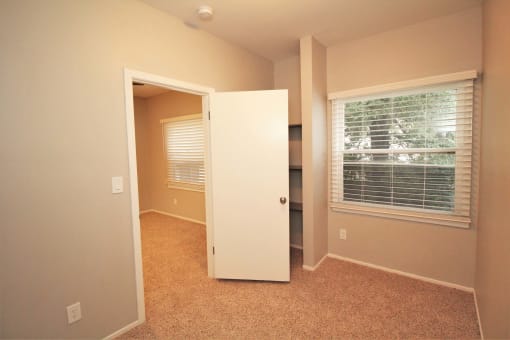 a room with a window and a door and a closet