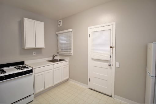 a kitchen with a stove and a sink and a refrigerator