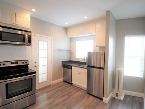 a kitchen with stainless steel appliances and white cabinets