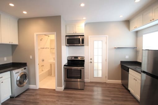 a renovated kitchen with stainless steel appliances and a laundry room