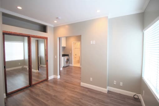 a living room with a large mirror and a wooden floor