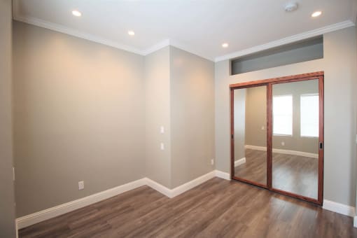 a living room with a mirror and hardwood floors