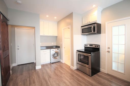 a renovated kitchen with stainless steel appliances and white cabinets
