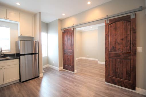 a kitchen with a stainless steel refrigerator and a wooden door