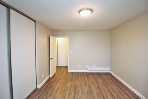 a living room with wood flooring and a door to a closet