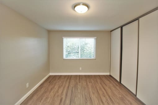 an empty room with white walls and a window