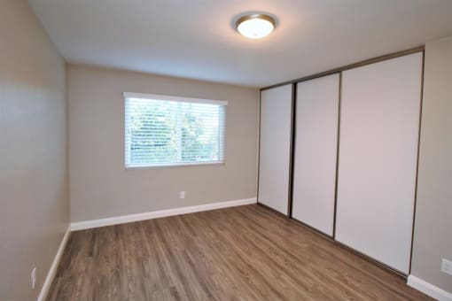 an empty room with white closets and a window