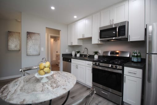 a kitchen with stainless steel appliances and white cabinets