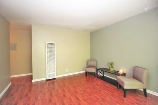 a living room with a hard wood floor and two chairs