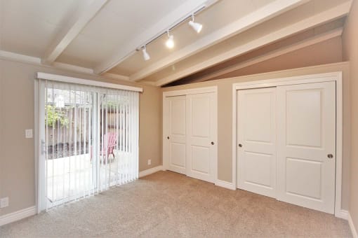 a bonus room with two closets and a door to a patio