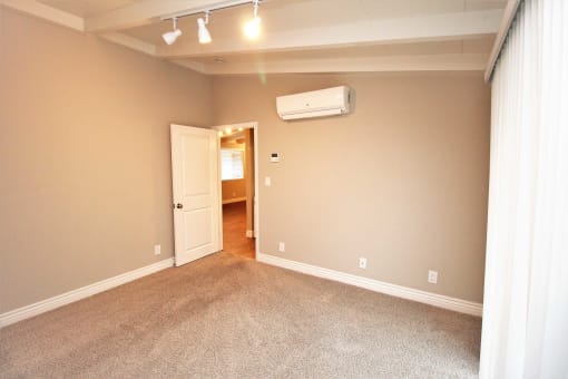 an empty living room with a heater on the wall