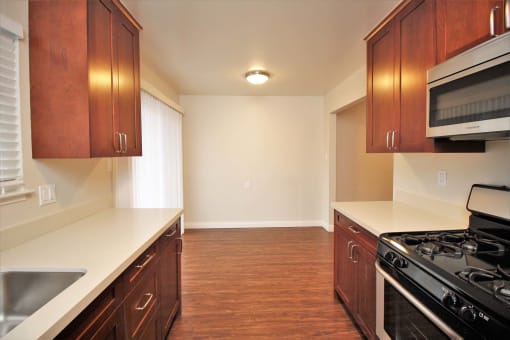 full kitchen in a new home with wood flooring and white counter tops