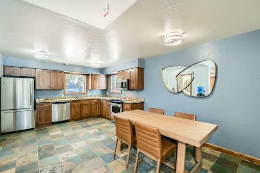 A kitchen with a table and chairs.