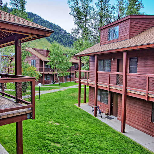A mountain is behind a building with red siding.