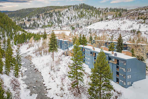 A building with a grey roof is surrounded by snow.