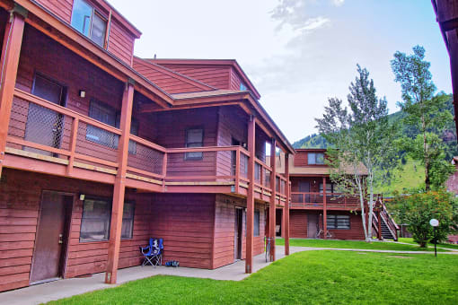 a large wooden house with a porch and a lawn