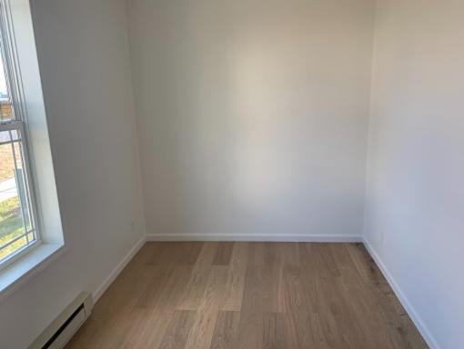 a empty room with wooden floors and a window
