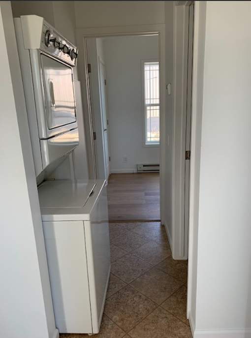an empty kitchen with a white refrigerator and a door
