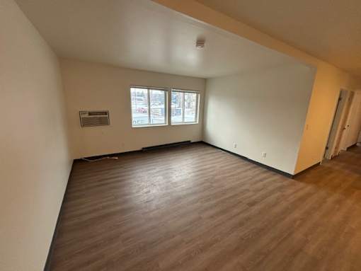 A room with wooden flooring and a window.