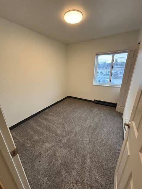 A small room with a window and a light on the wall.