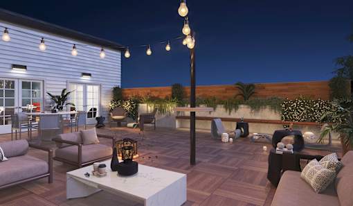 A patio with a table, chairs, and string lights.