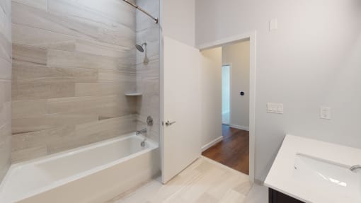 a bathroom with a tub and a shower and a sink