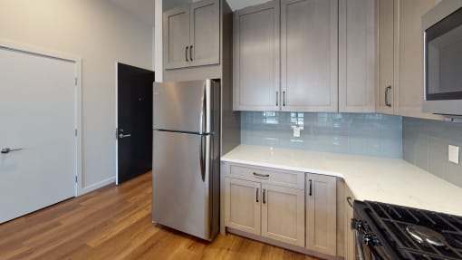 a kitchen with white cabinets and a stainless steel refrigerator