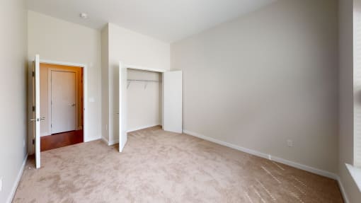 an empty room with a closet and a door to a wardrobe