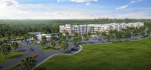 A large building complex with a parking lot in front at Manor East Apartments, Manor, TX, 78653 