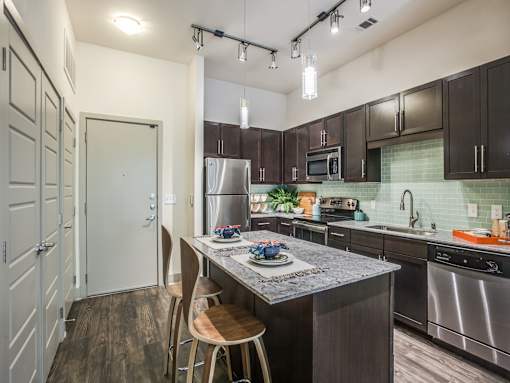 A kitchen with a granite countertop and stainless steel appliances.at Infinity on Yorktown, Dallas